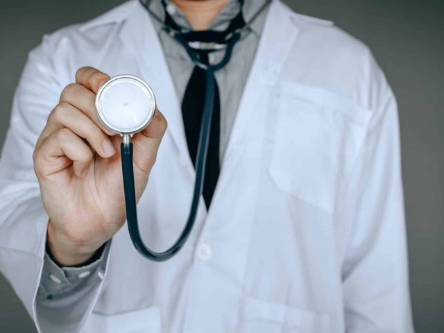 Male doctor holding stethoscope.